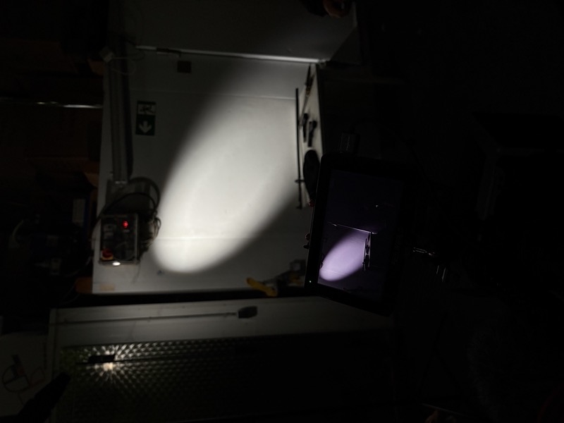 Behind the scenes on set: a monitor and a spotlight in a dark room during a video shoot